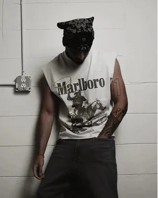 Lifestyle shot of a man in a sleeveless shirt with graphic print.