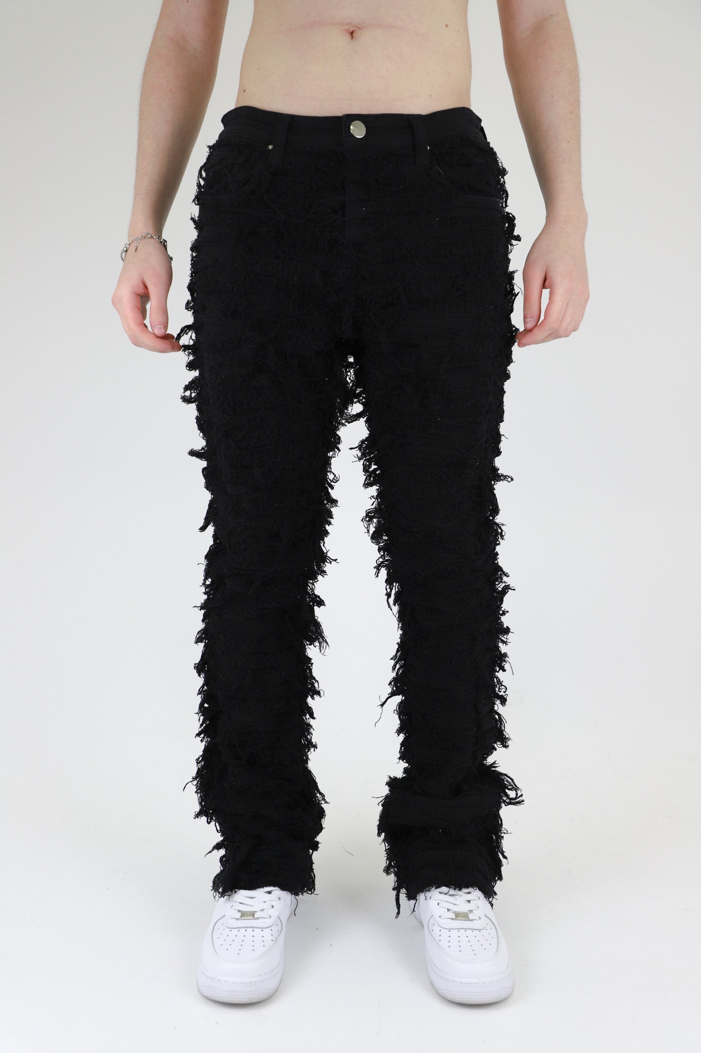 Front view of black fitted jeans showcasing five pockets.