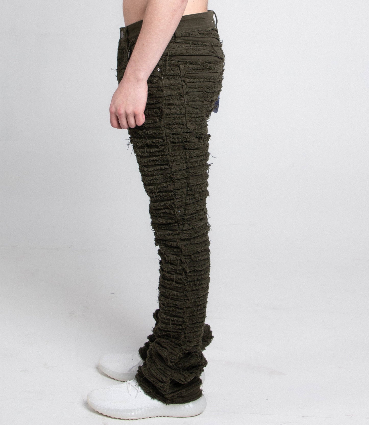 Side view of green fitted jeans with five pockets.