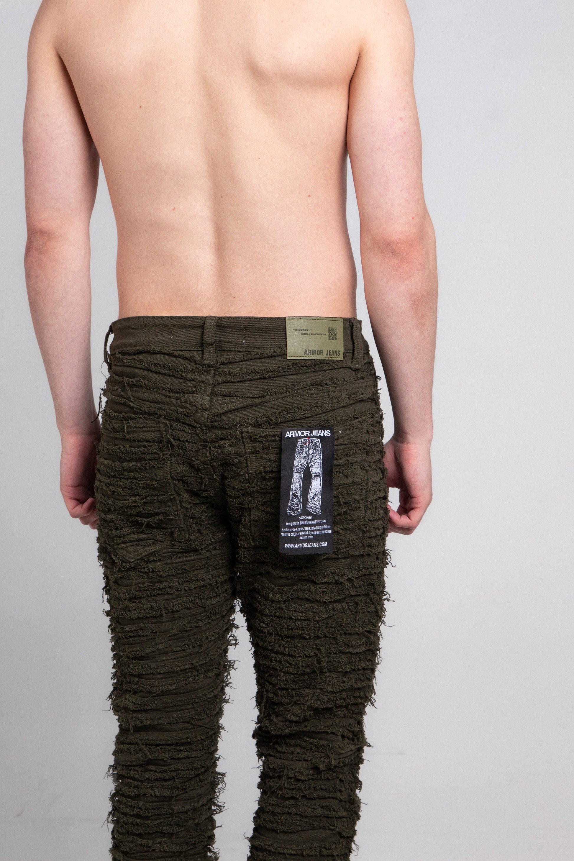 Back view of green slim fit jeans with tag attached.