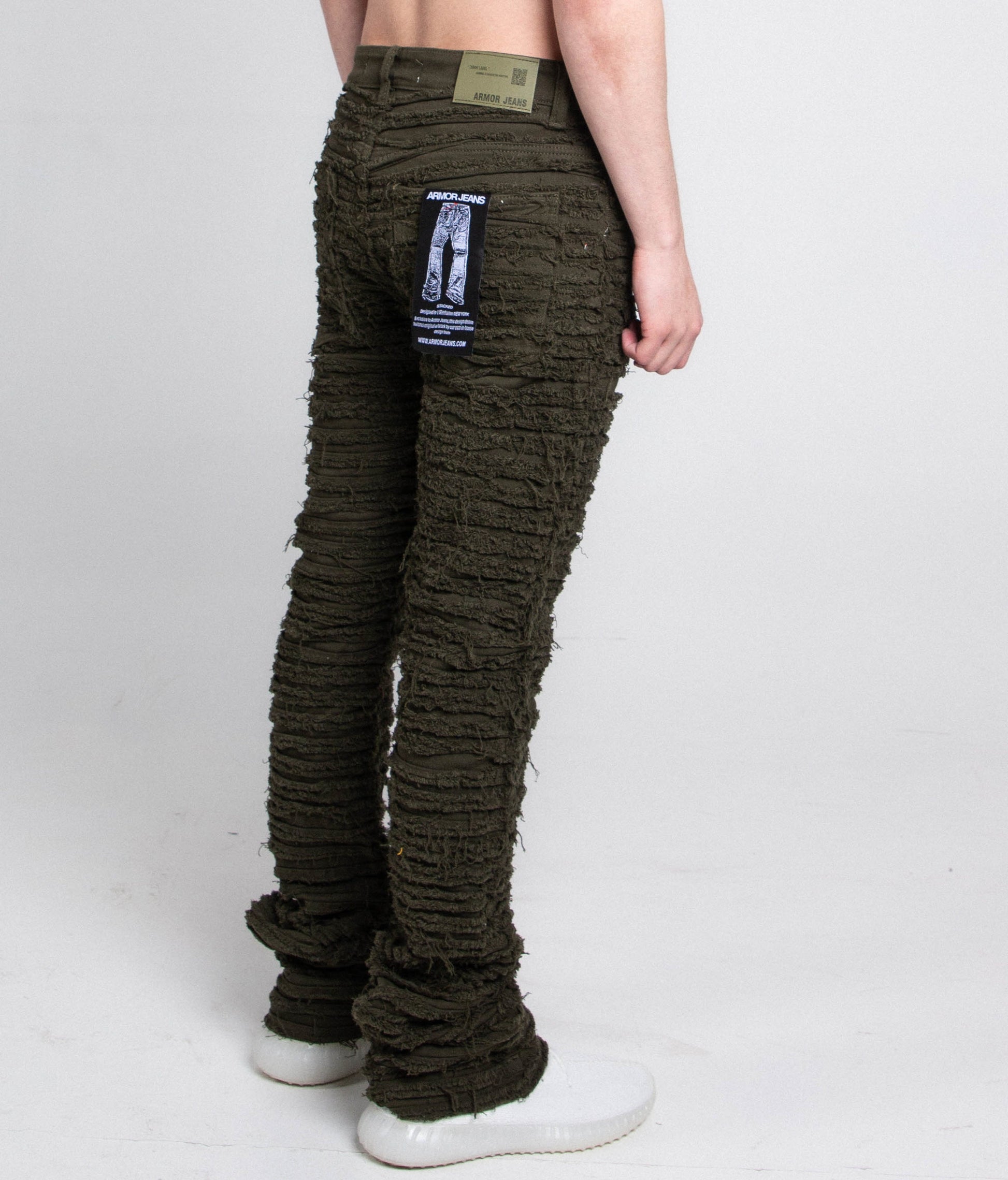 Back view of green slim fit jeans with tag attached.