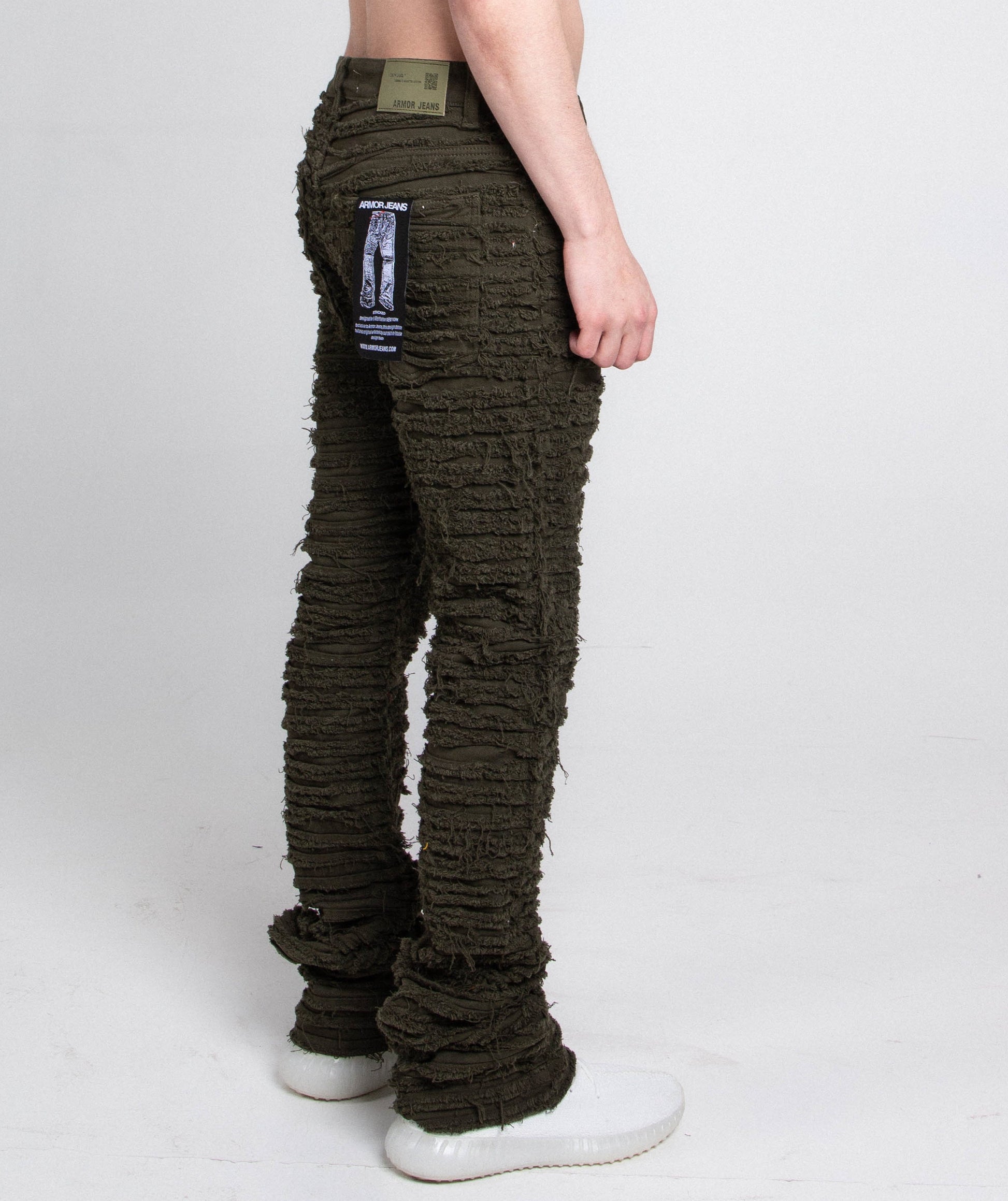 Back view of green slim fit jeans with tag attached.
