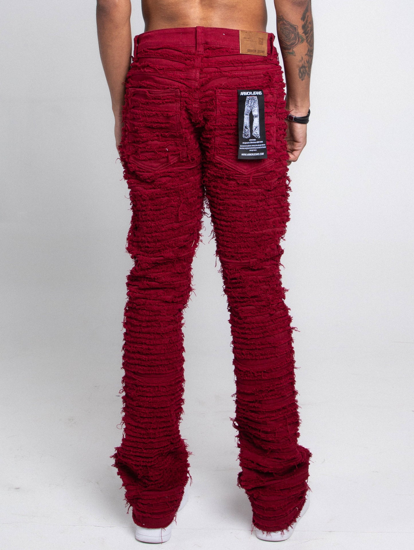 Back view of red fitted jeans with a tag attached.