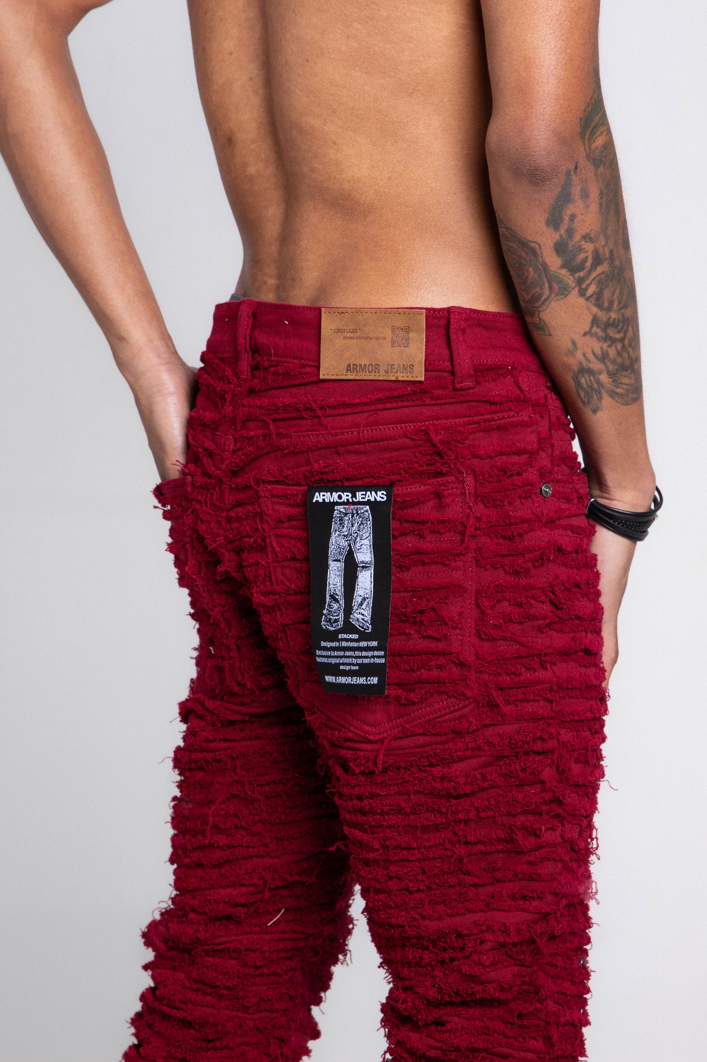 Detail view of red jeans showing back pocket.