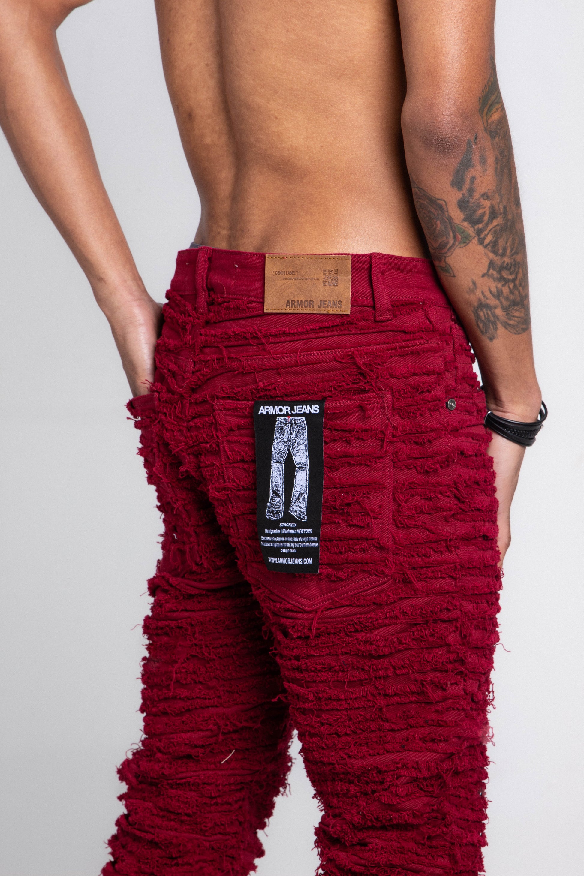 Front view of red fitted jeans with five pockets.