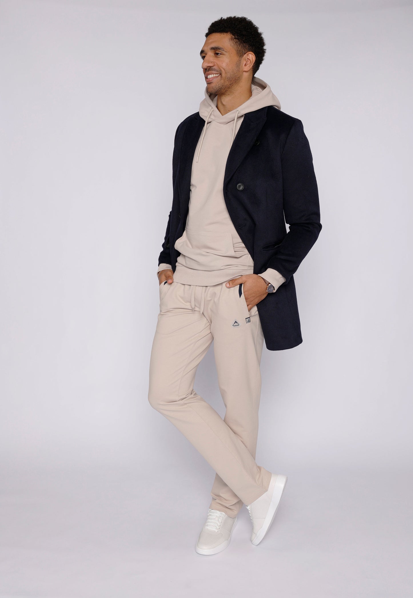 Beige sweatpants in lifestyle shot with a hooded top.