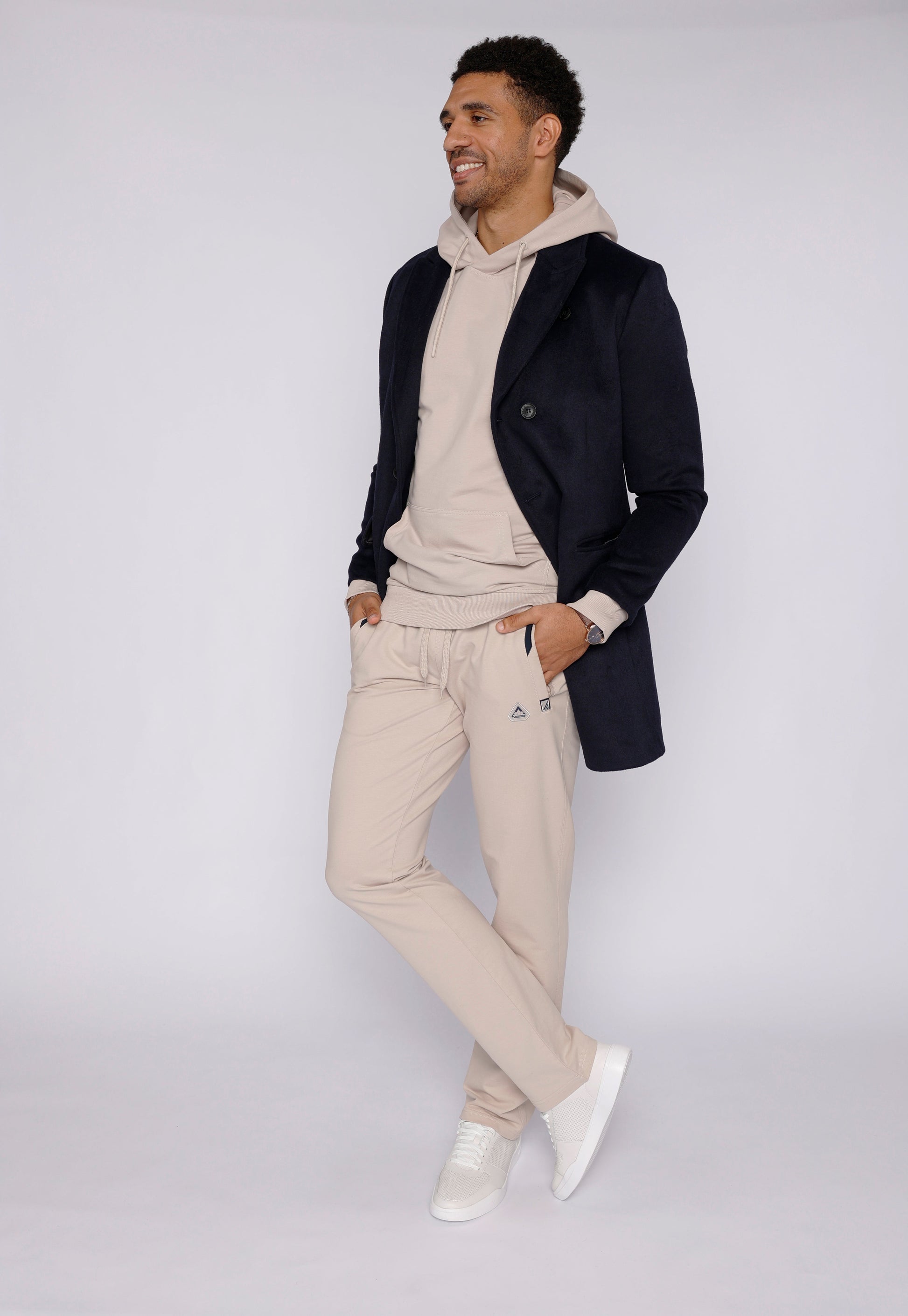 Beige sweatpants in lifestyle shot with a hooded top.
