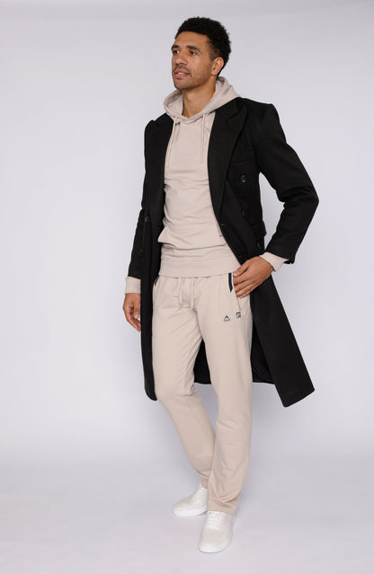 Beige sweatpants styled with a long coat in lifestyle shot.