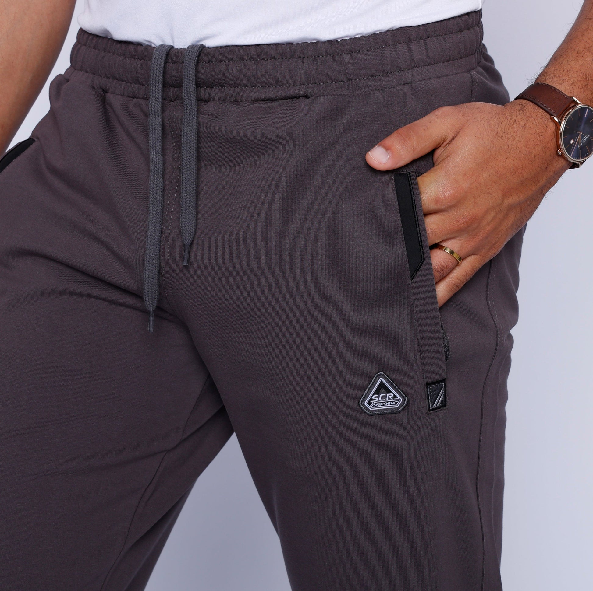 Detail view of black straight leg pants with an elastic waistband and side pockets.