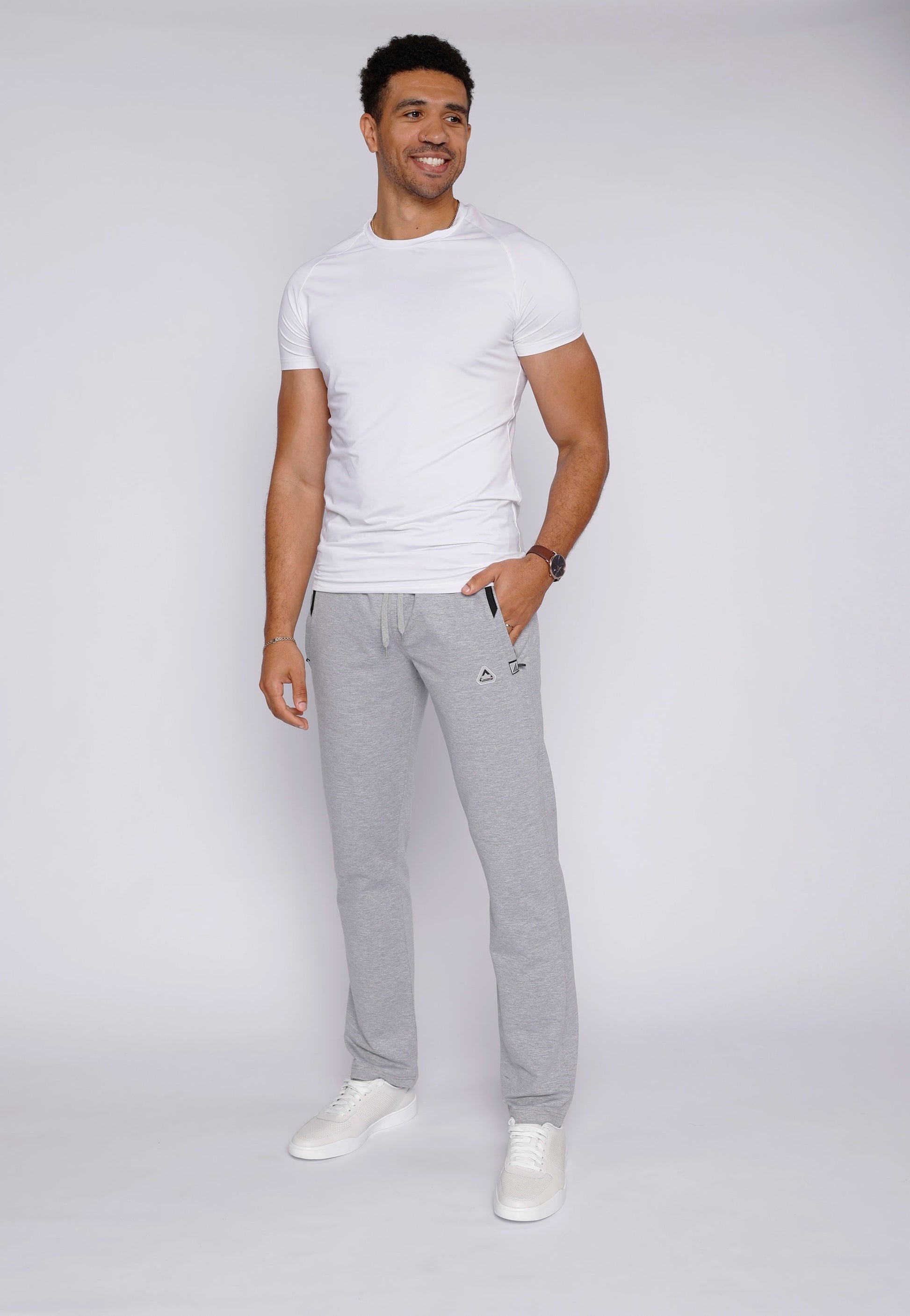 Detail view of athletic pants featuring a back pocket and side stripes.