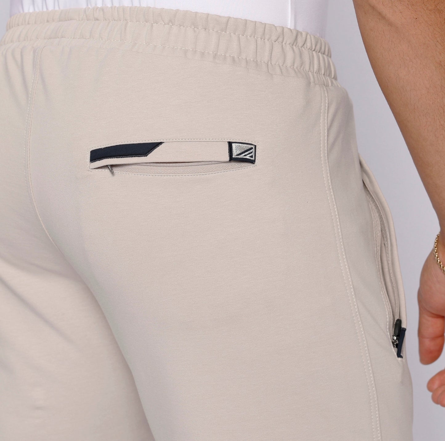 Detail view of beige travel pants featuring an elastic waistband.