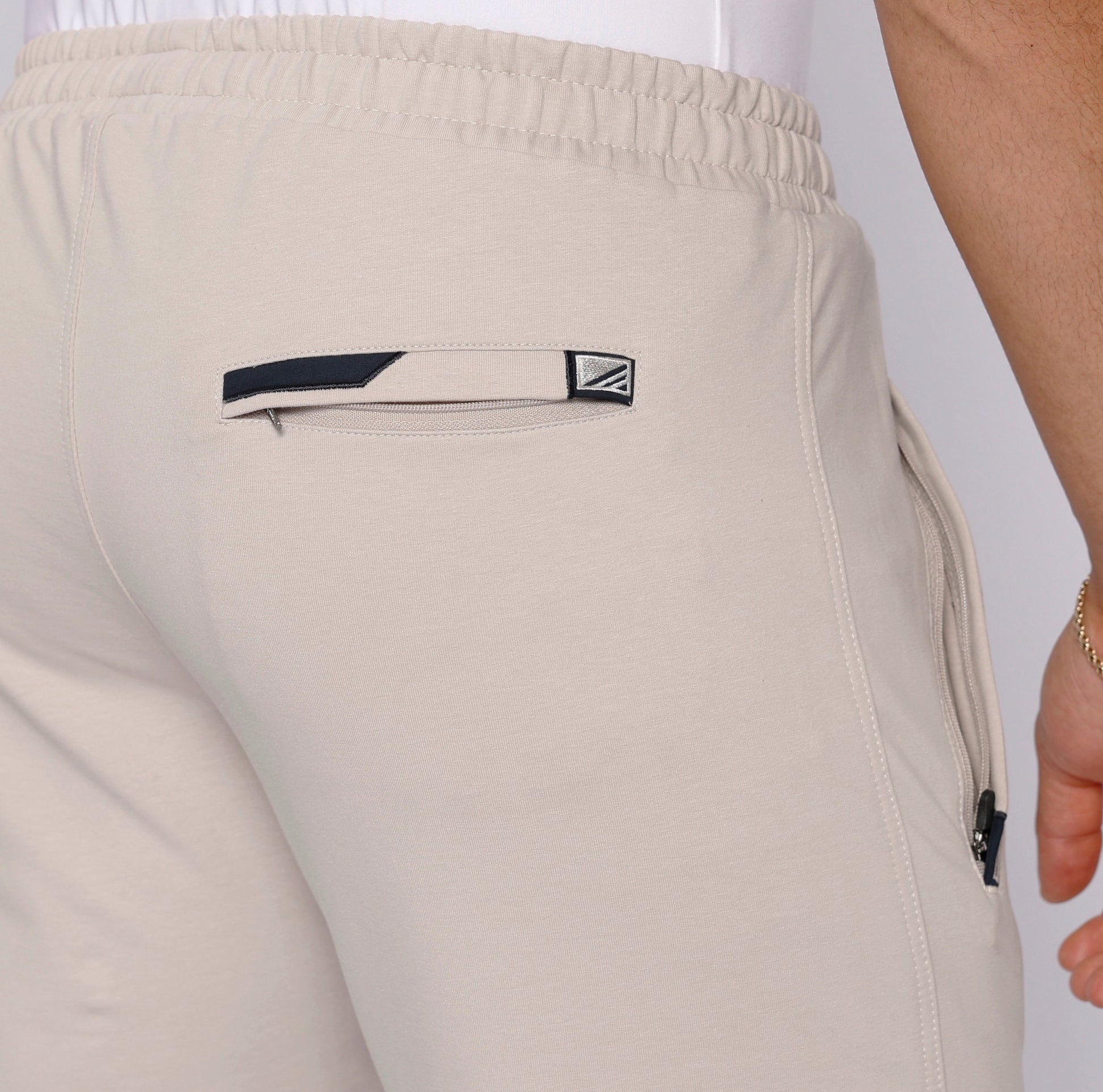 Detail view of beige travel pants featuring an elastic waistband.