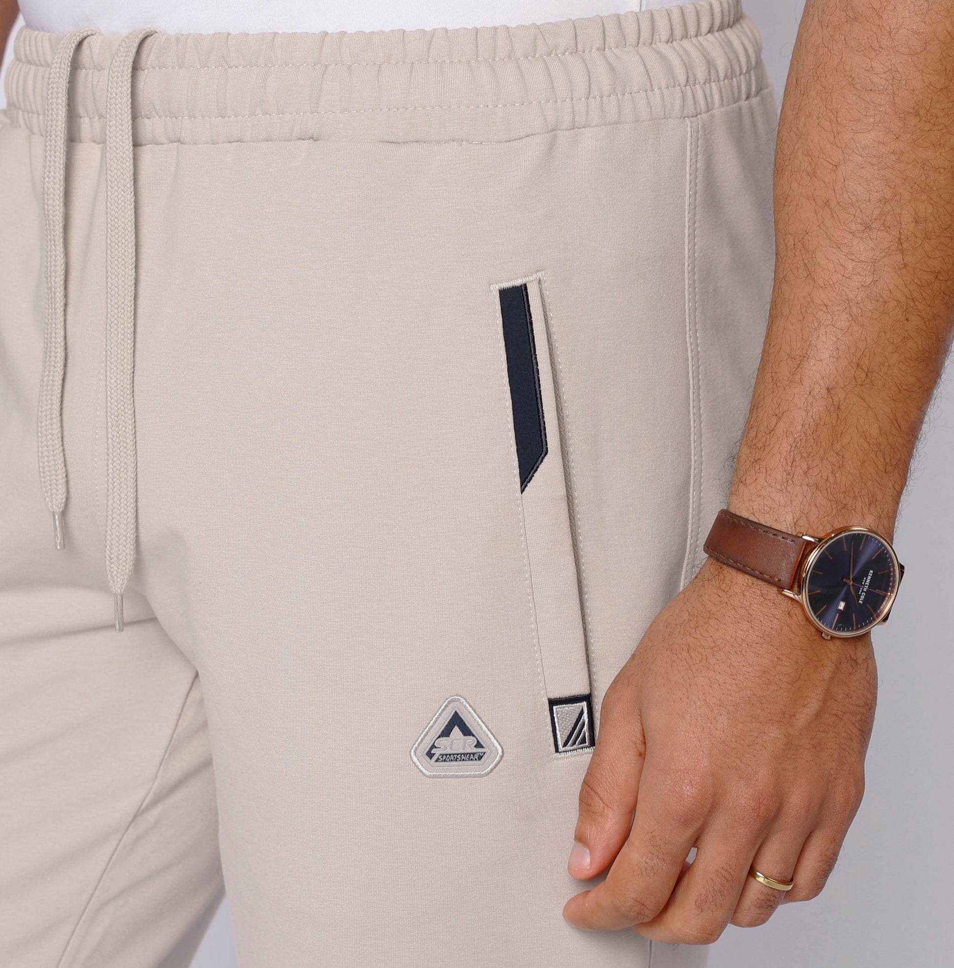 Detail shot of beige travel pants with zipper pockets.