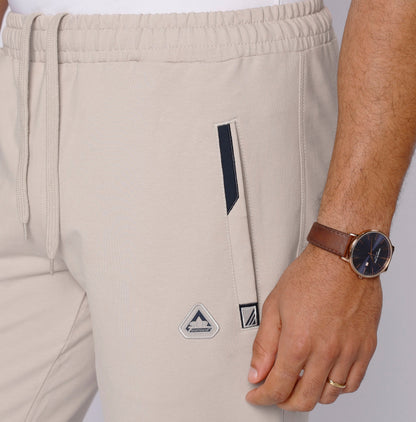 Detail shot of beige travel pants with zipper pockets.