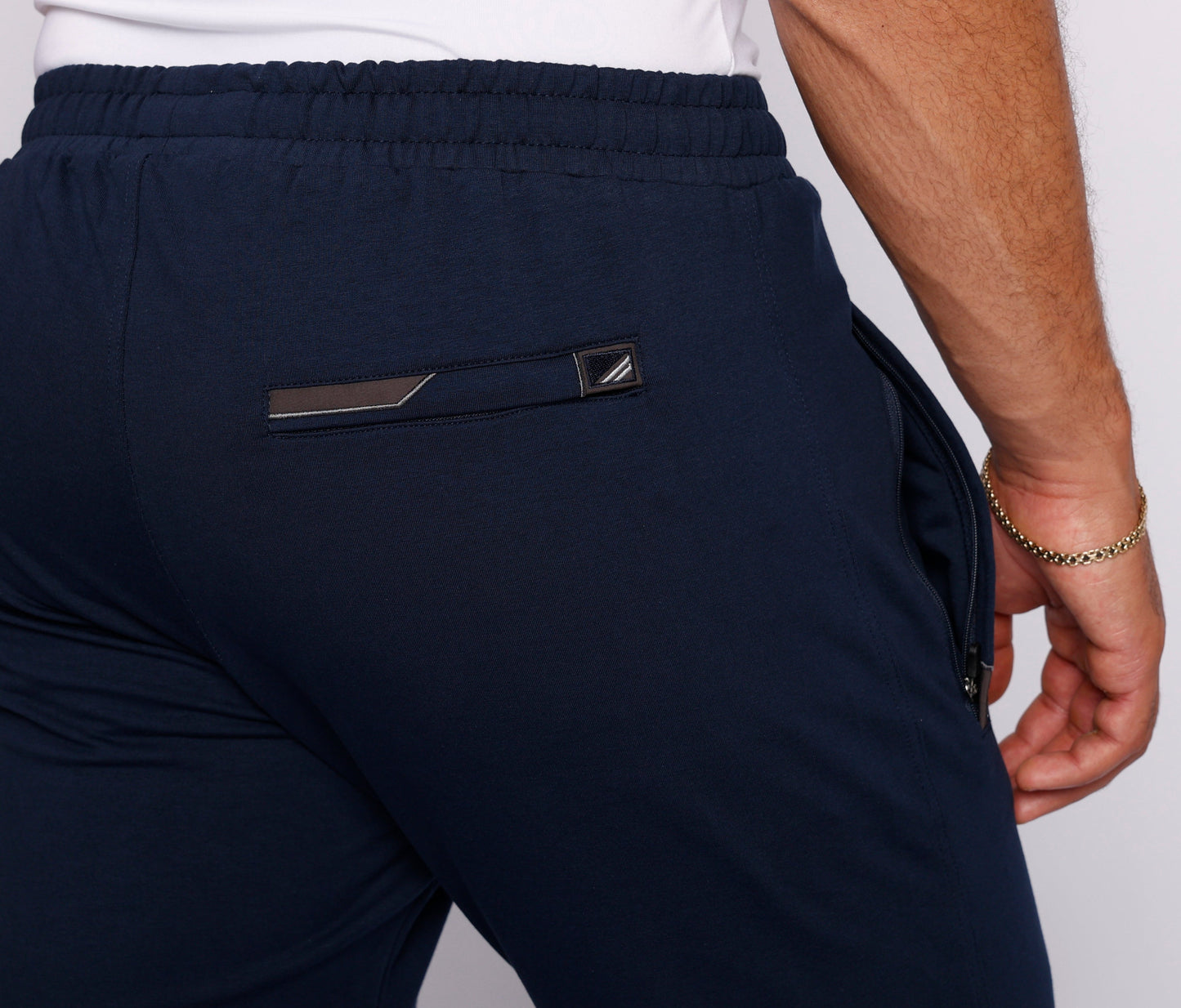 Detail view of dark navy athletic pants with a back pocket.