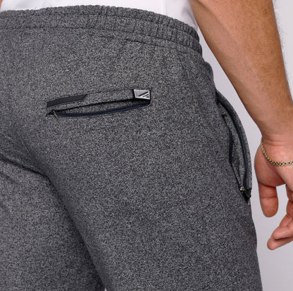 Detail shot of gray sweatpants with a back pocket and zipper.
