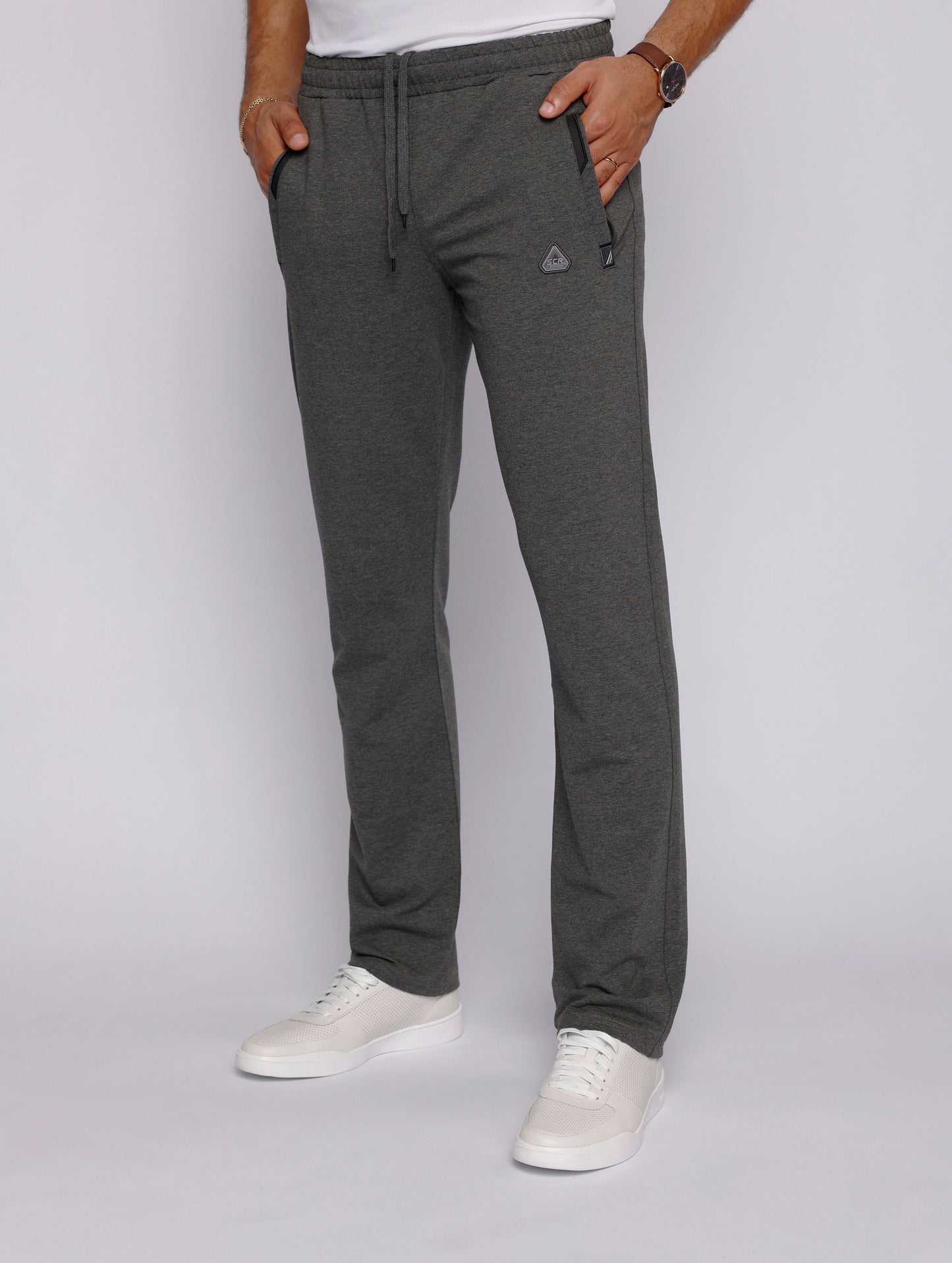 Lifestyle shot of a man wearing gray sweatpants in a casual setting.