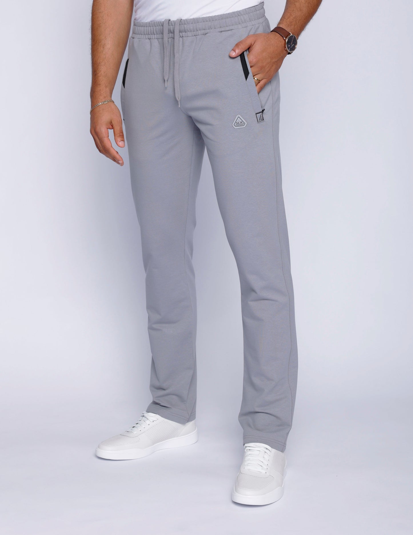 Detail shot of gray sweatpants featuring side pockets.