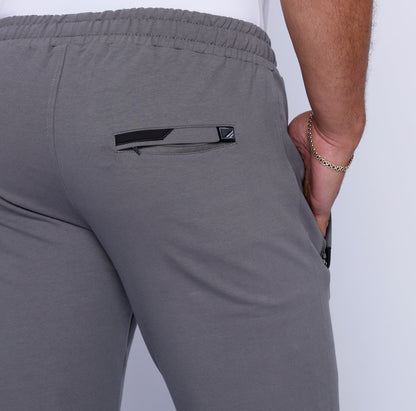 Back view of grey sweatpants with a back pocket and elastic waistband.
