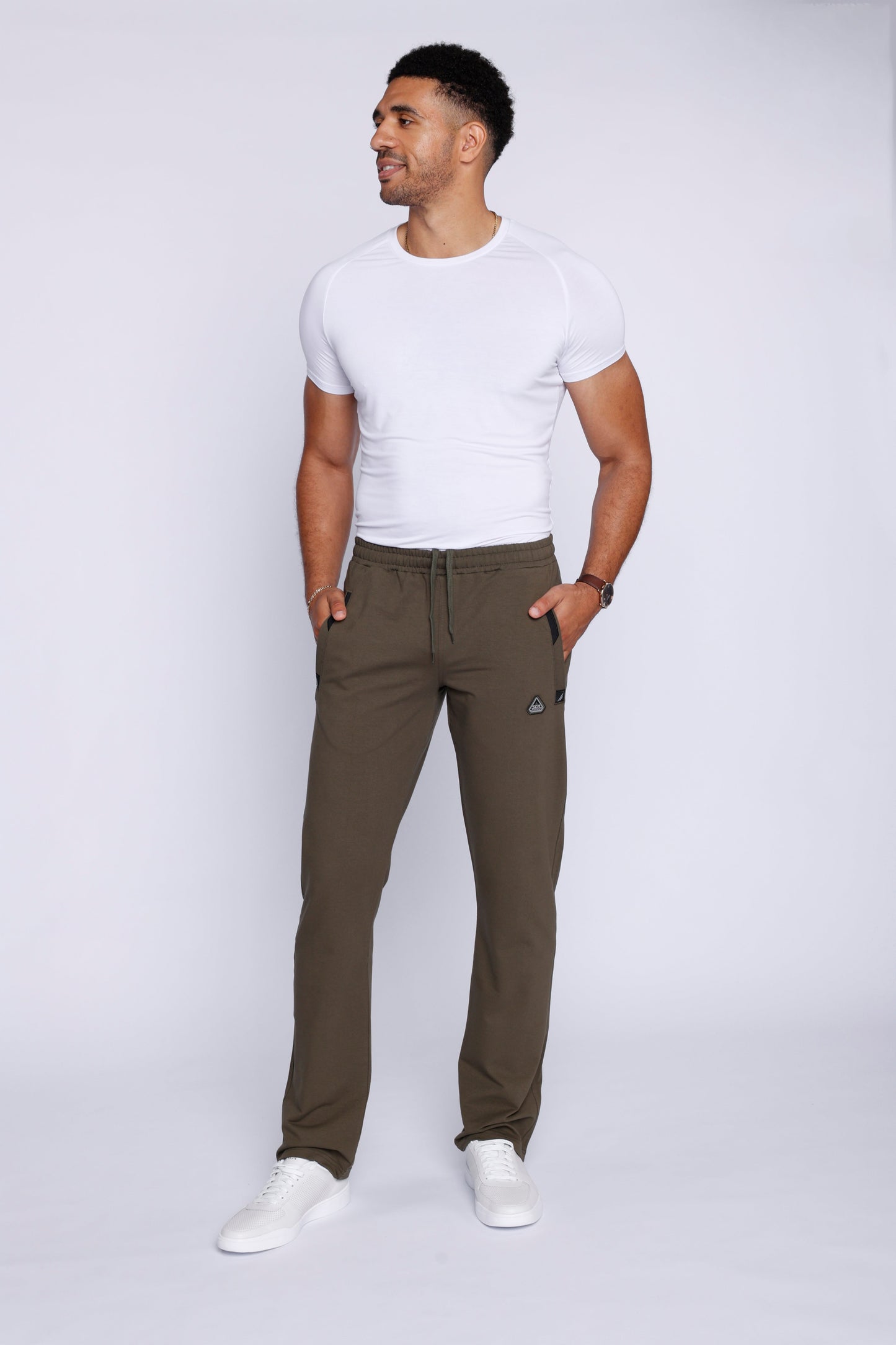 Lifestyle shot of khaki green athletic pants in a studio setting.