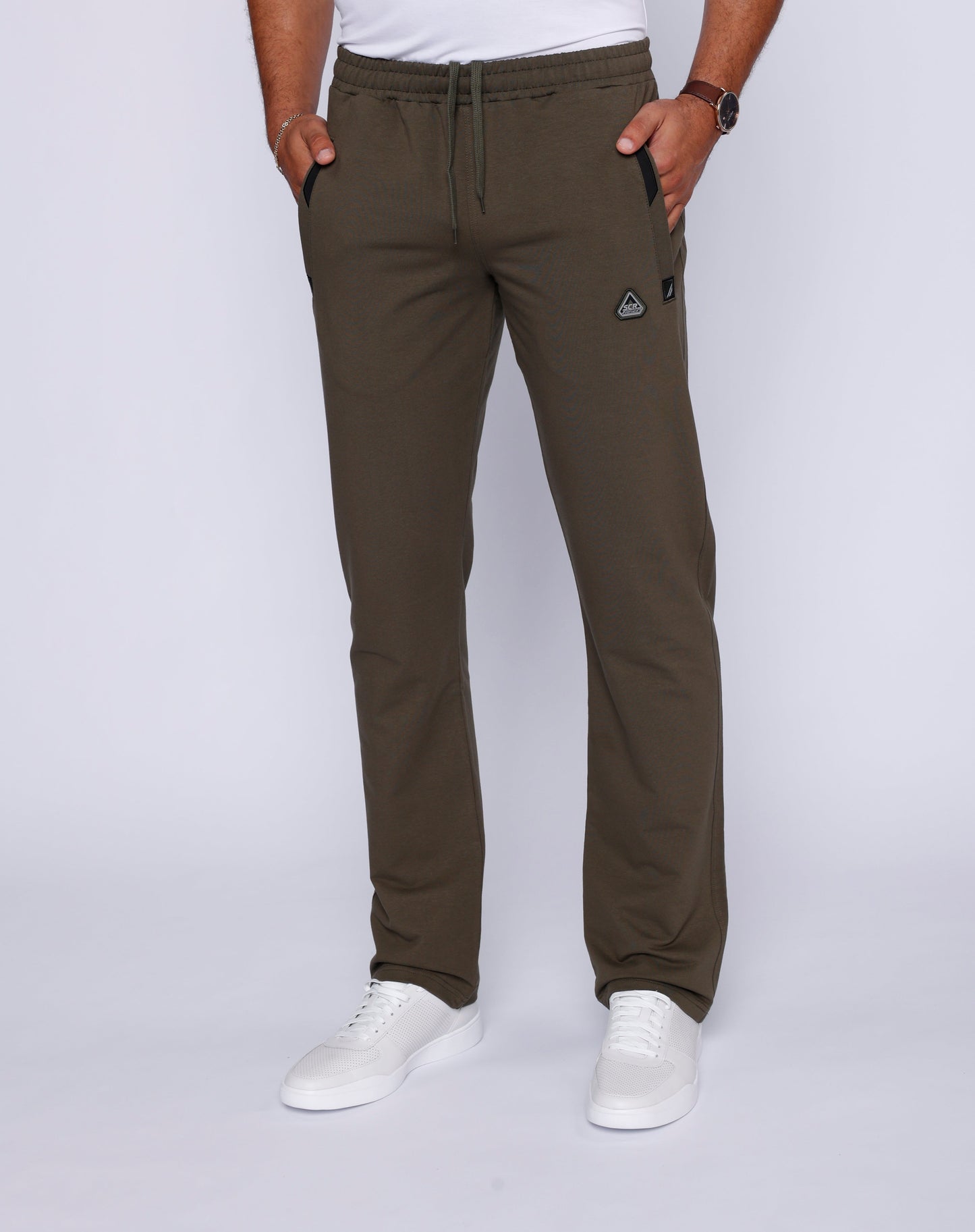 Lifestyle shot of khaki green pants with two front pockets and elastic waistband.