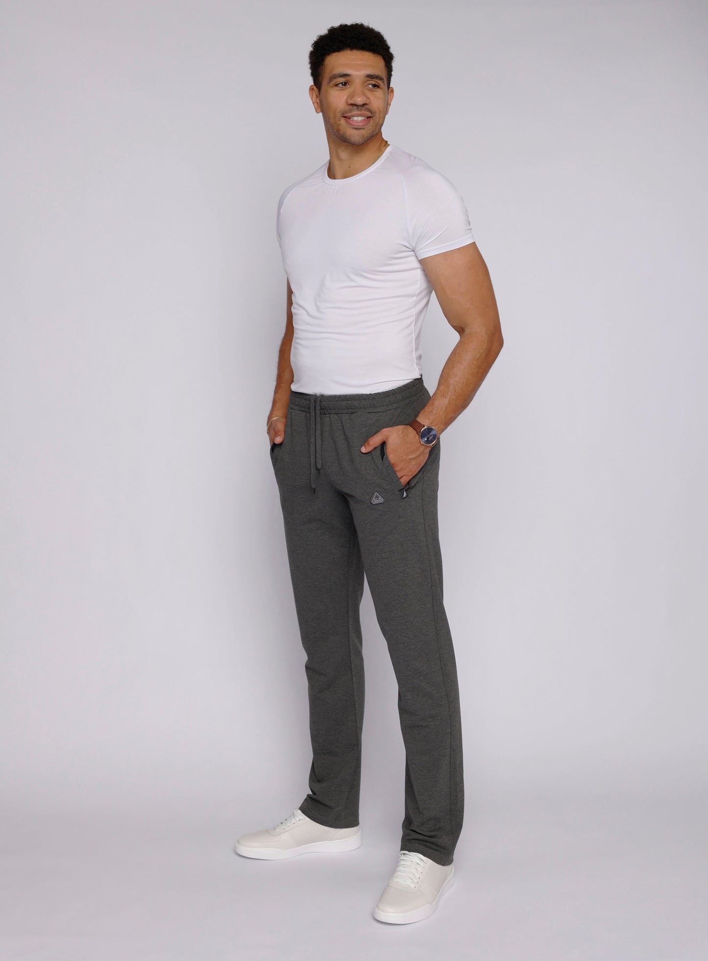 Lifestyle shot of a man wearing gray sweatpants with side pockets.