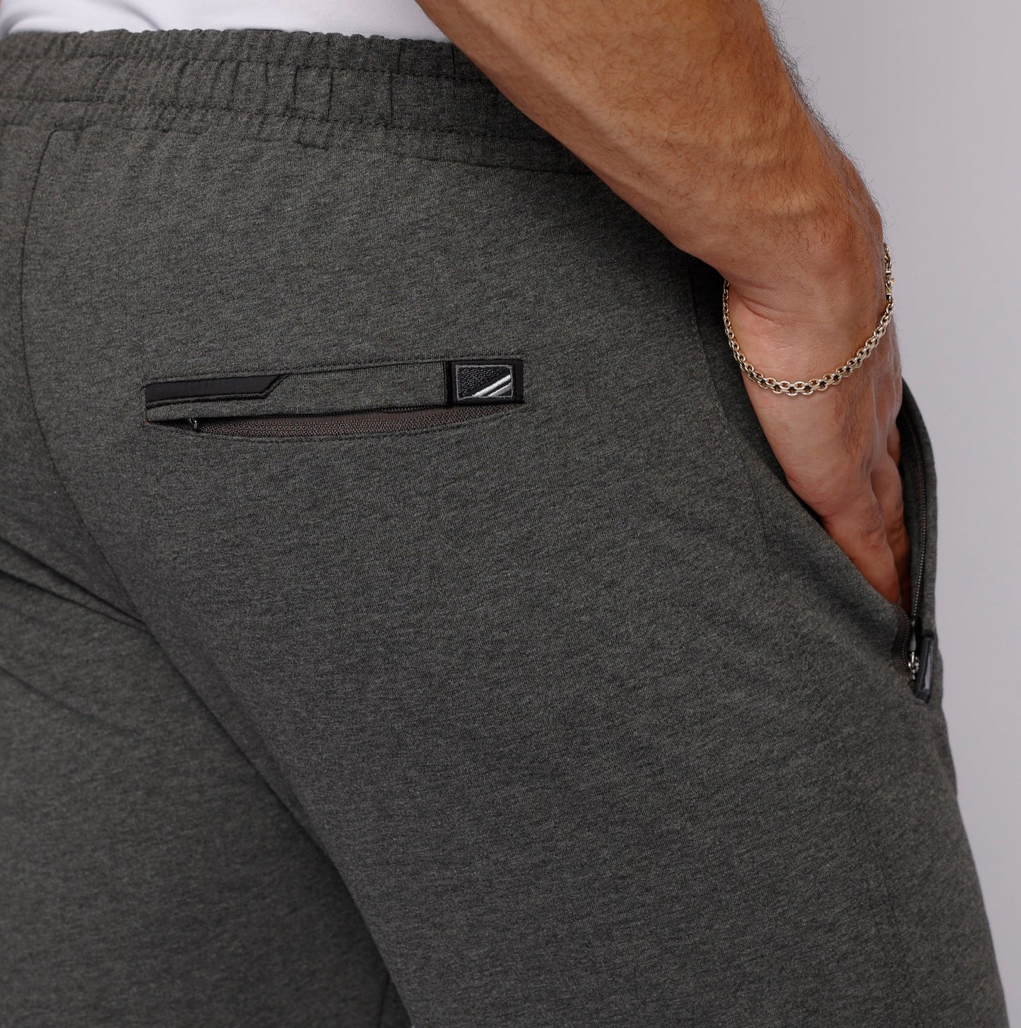 Detail of long inseam sweatpants for men with elastic waistband in gray.