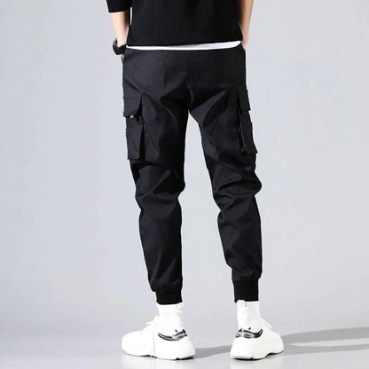 Back view of black Harajuku men's pants with pockets and elastic cuffs.