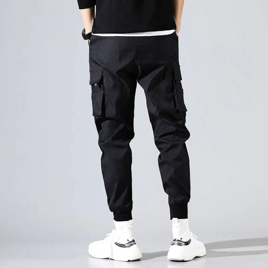 Back view of black Harajuku men's pants with pockets and elastic cuffs.