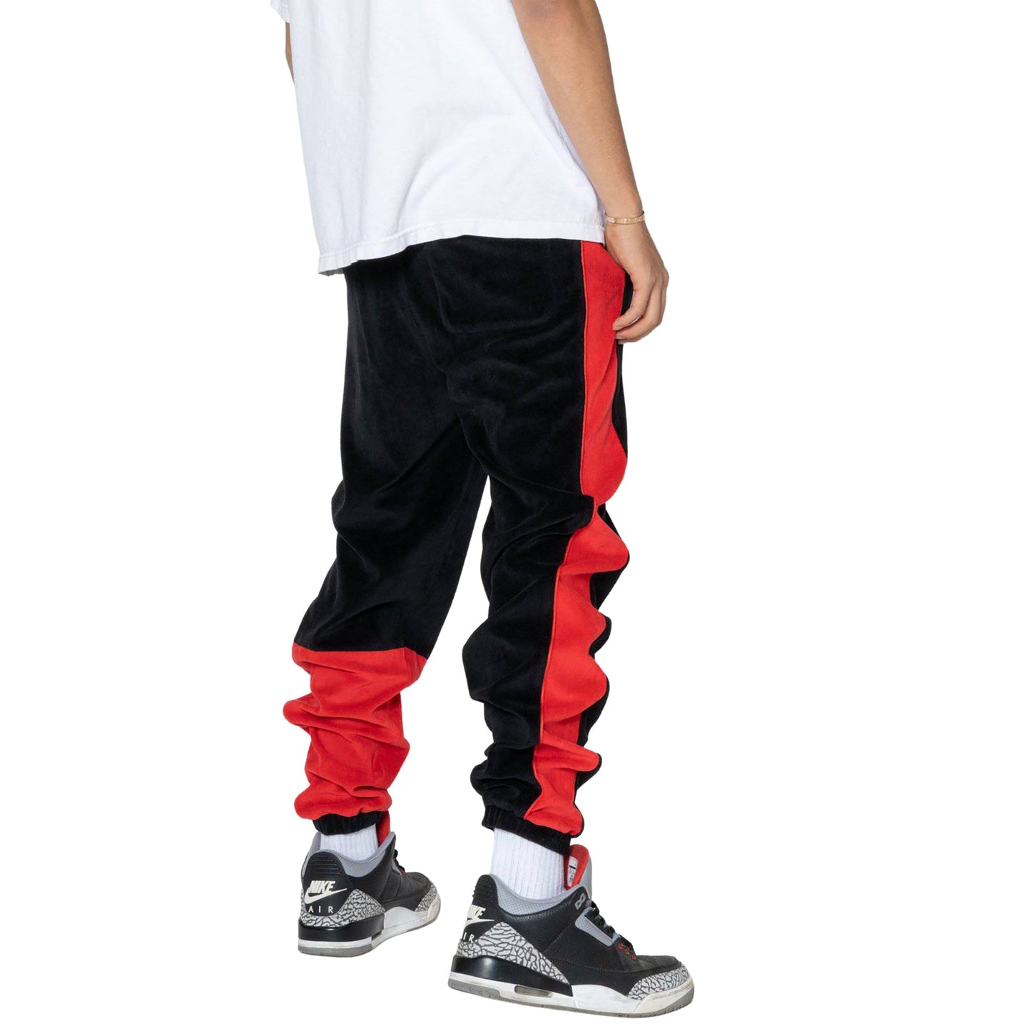 Back view of black joggers showcasing elastic waistband and red side stripes.