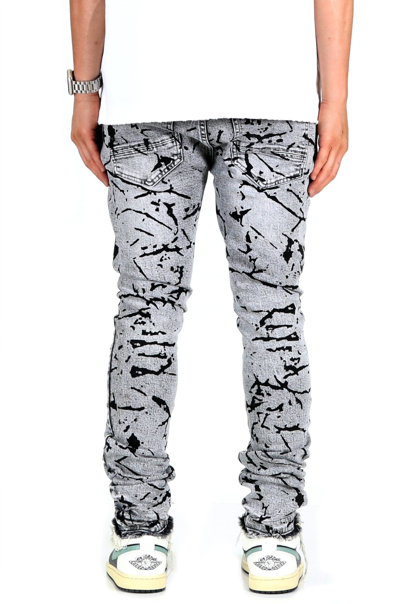 Side view of black and white graphic print skinny denim pants.