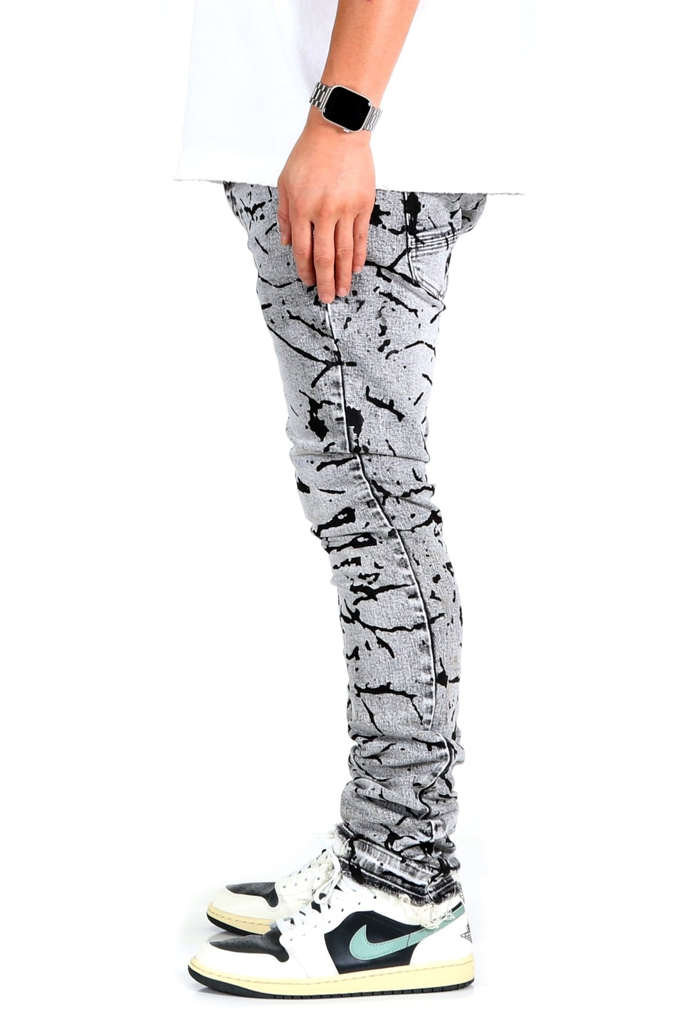 Side view of black and white graphic print skinny denim pants.