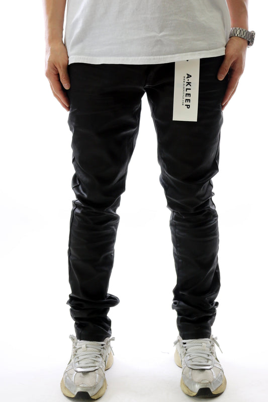 Front view of the black wax coated skinny denim pants with a slim fit.