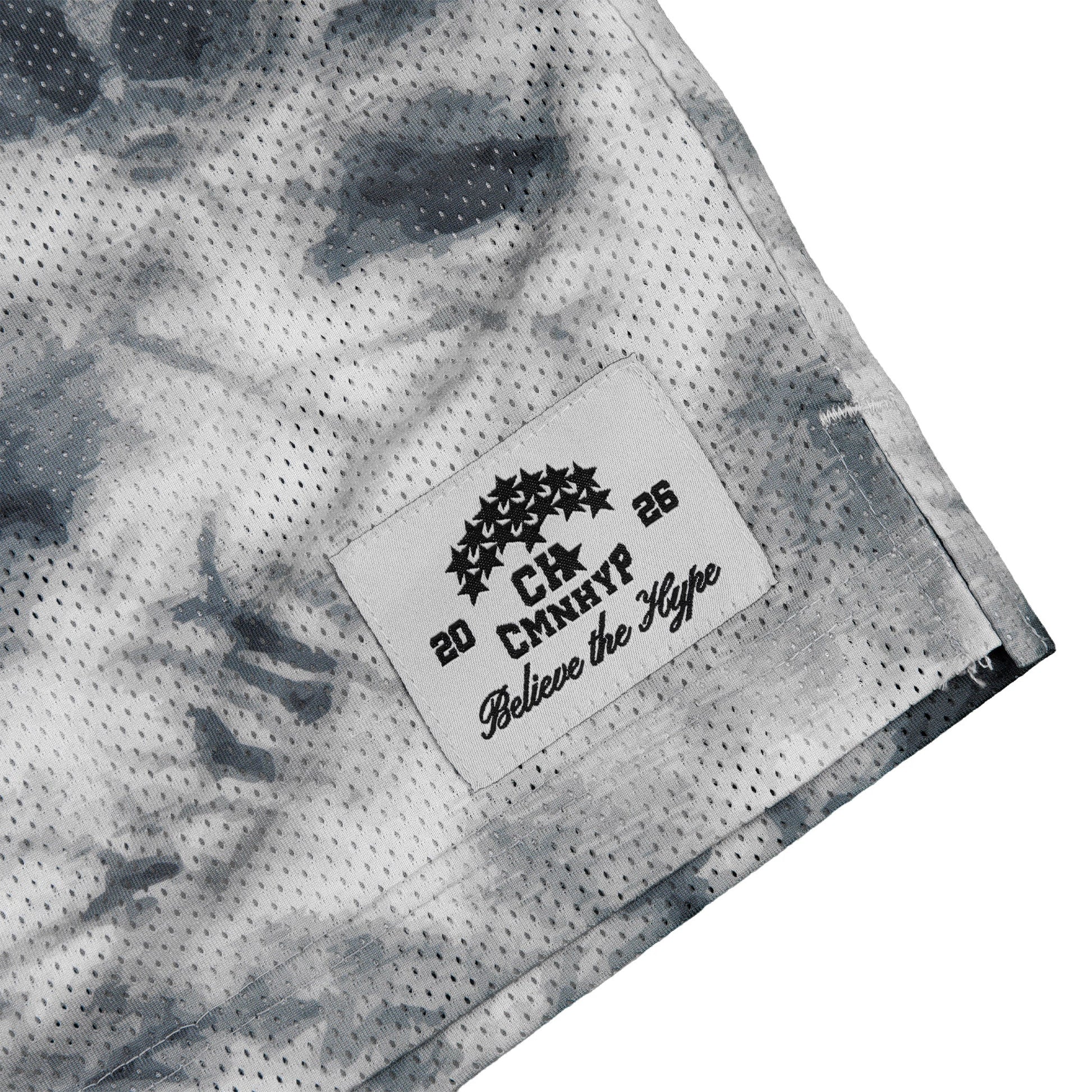 Detail shot of the brand label on the tie-dye shorts in grey and black.