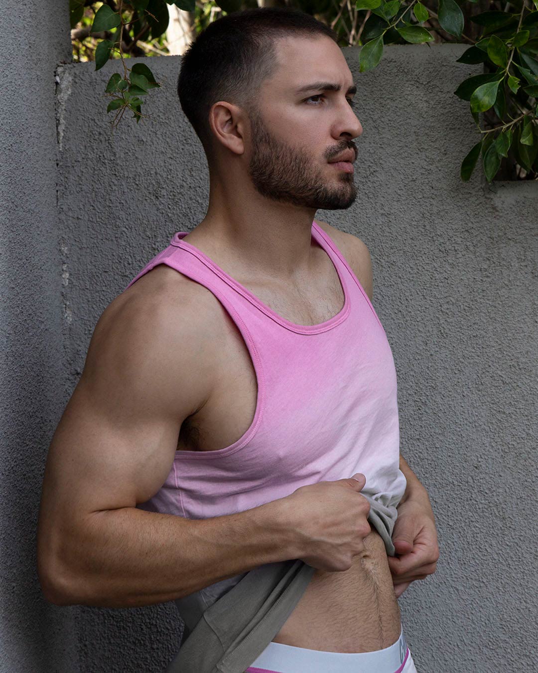 Lifestyle shot of a man in a pink tank top outdoors.