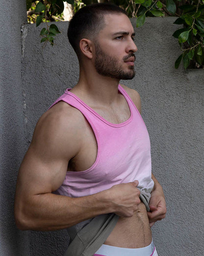 Lifestyle shot of a man in a pink tank top outdoors.