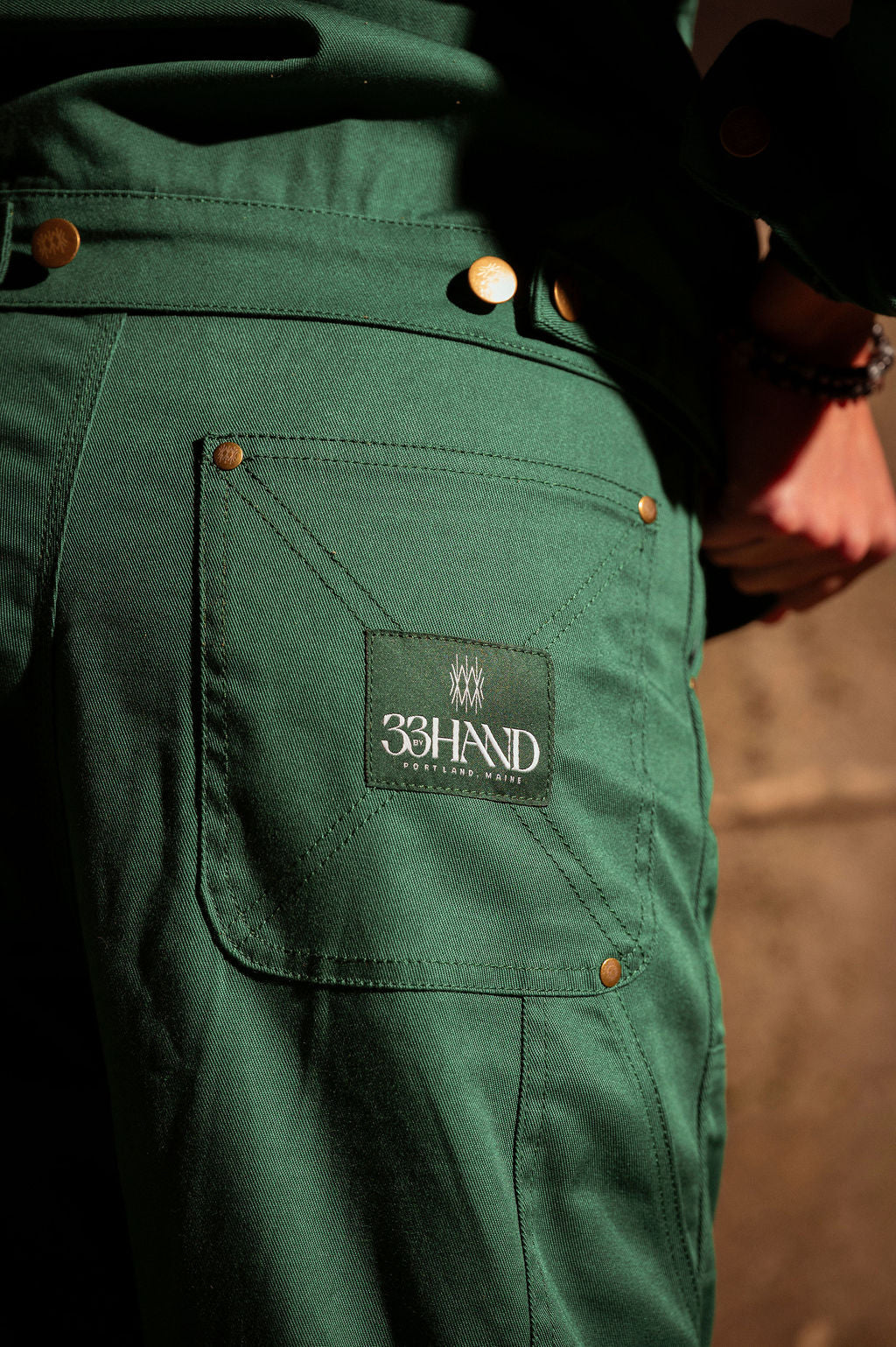 Detail view of the cotton twill work pant with back pocket and brand label.