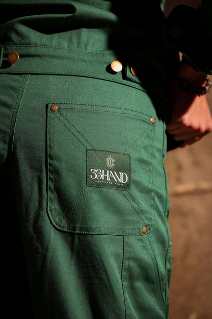 Detail view of the cotton twill work pant with back pocket and brand label.