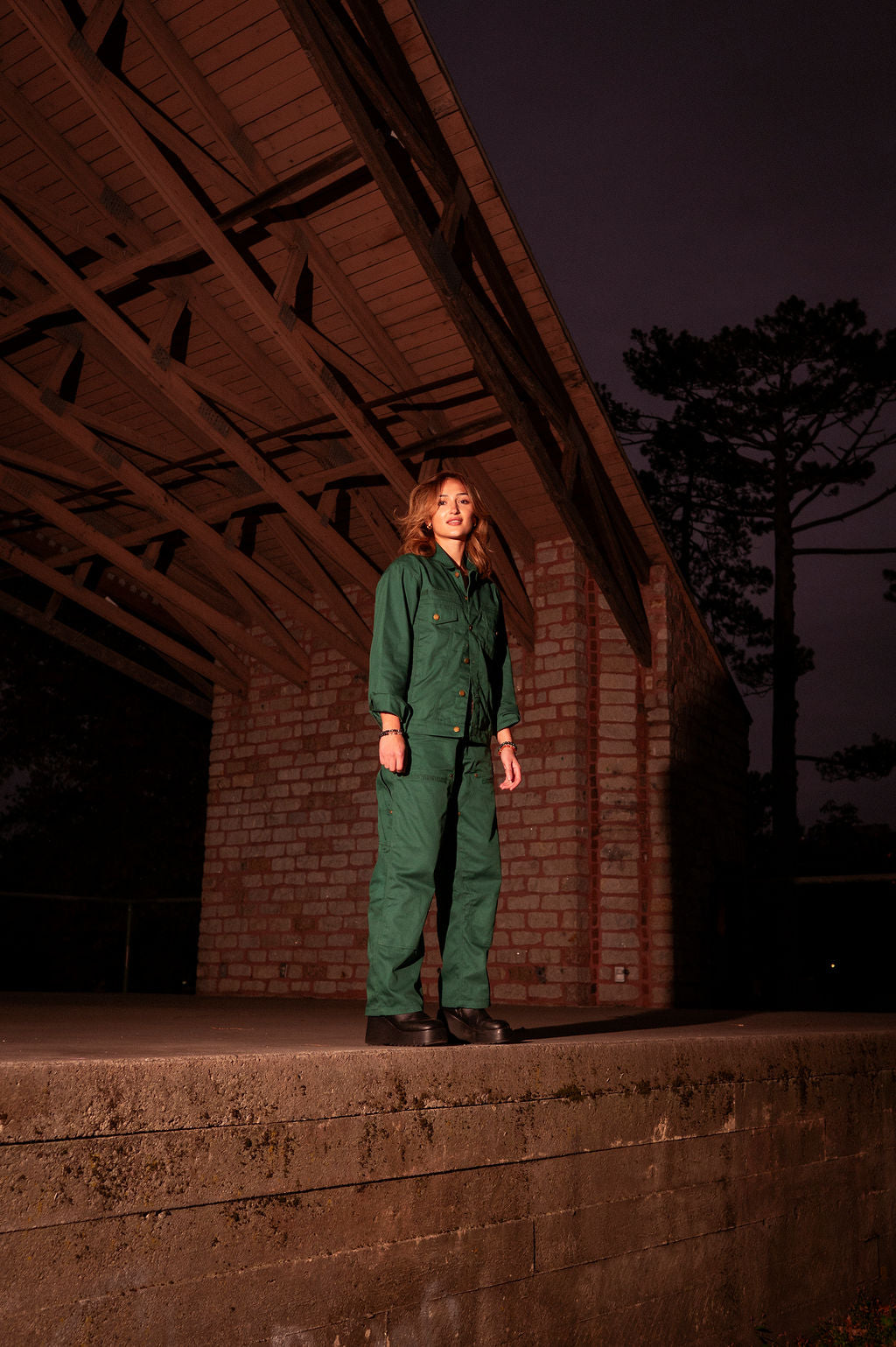 Lifestyle shot of a person wearing the cotton twill work pant in dim lighting.