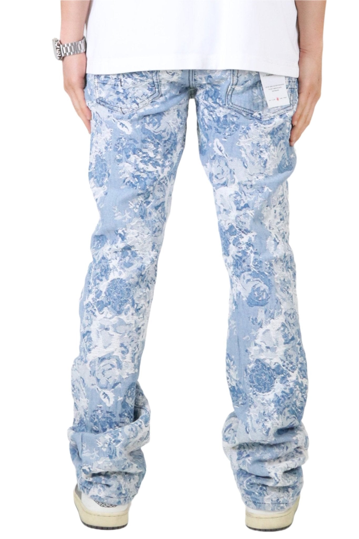 Back view of light blue jacquard denim pants featuring a distressed design.