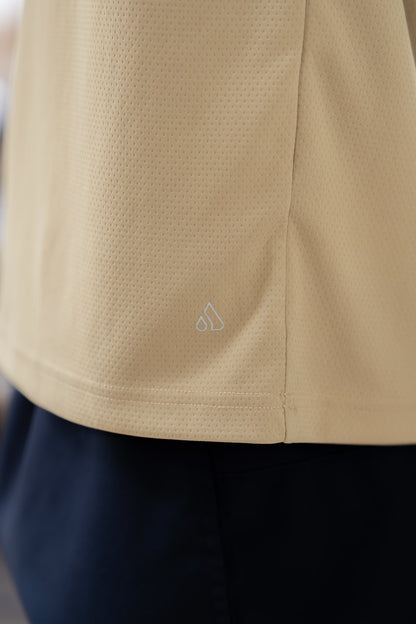 Close-up detail of the beige Journey Tee fabric, highlighting smooth texture.