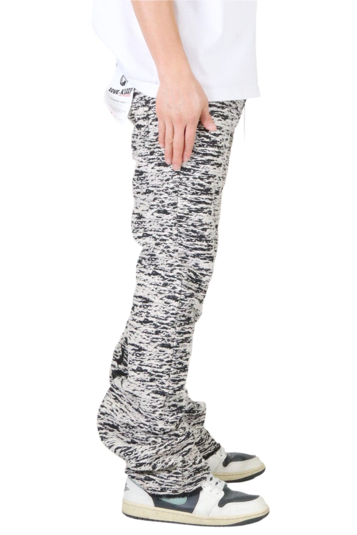 Side view of the black and white jacquard pattern slim fit denim pants.