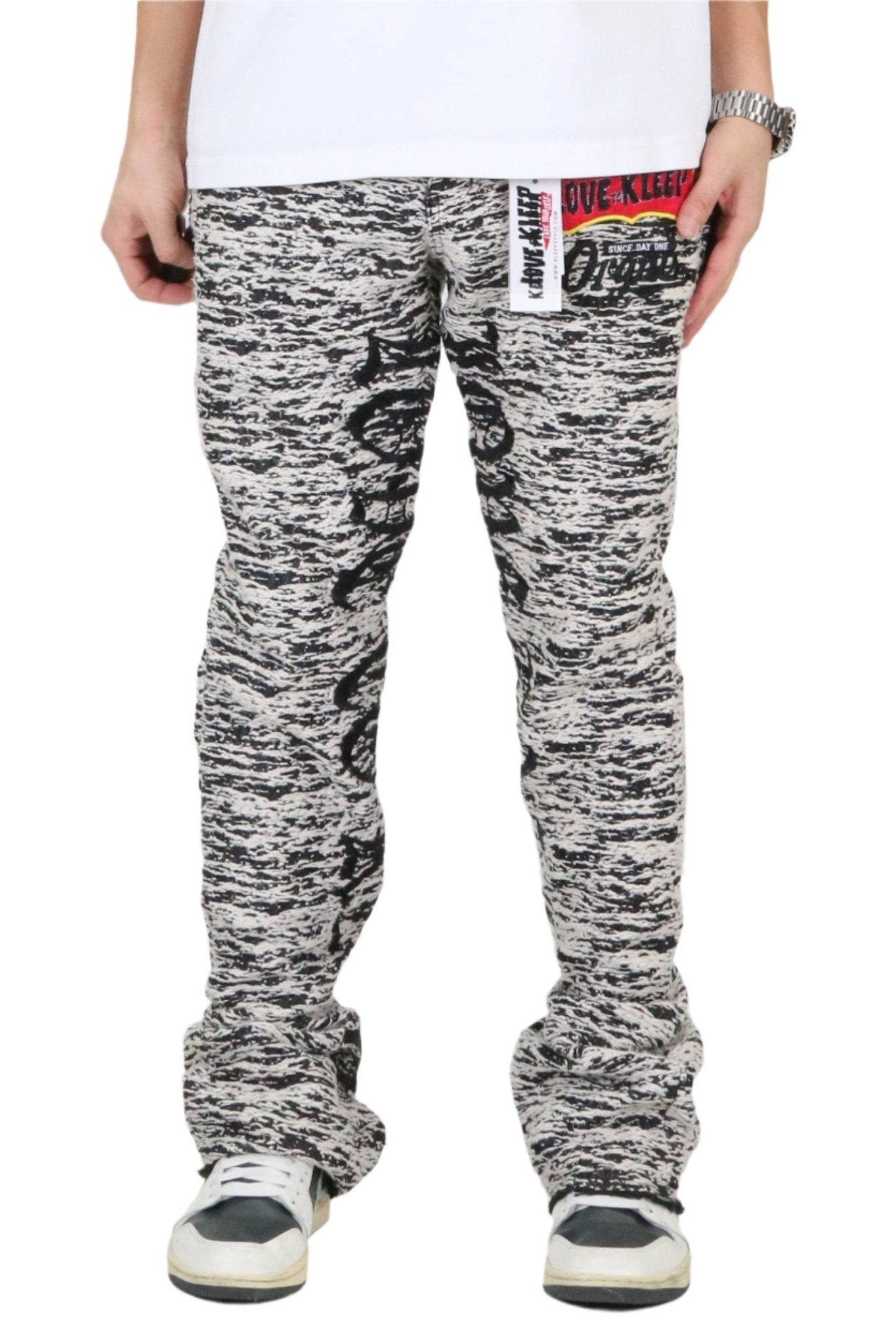 Front view of the black and white jacquard pattern stack fit denim pants.