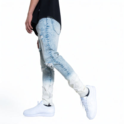 Side view of a man wearing blue faded jeans and sneakers.