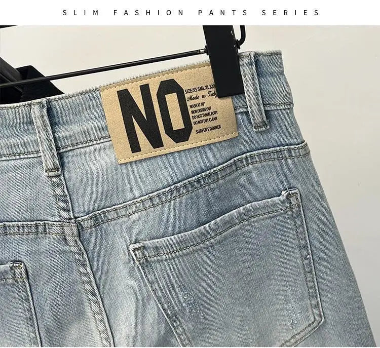 Detail of light blue jeans with distressed details and back label.