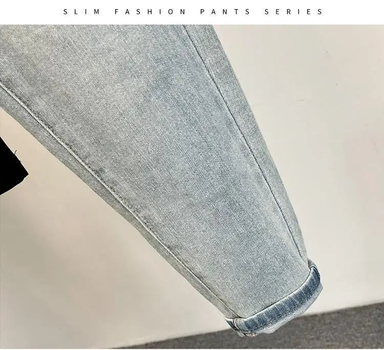 Detail of light blue jeans featuring a faded design and distressed details.