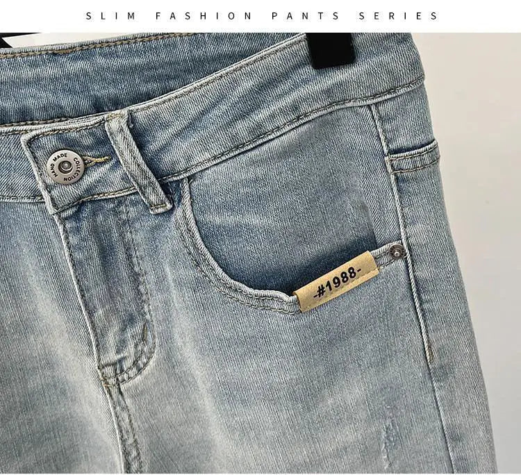 Close-up of light blue jeans featuring a front pocket and gold zipper.