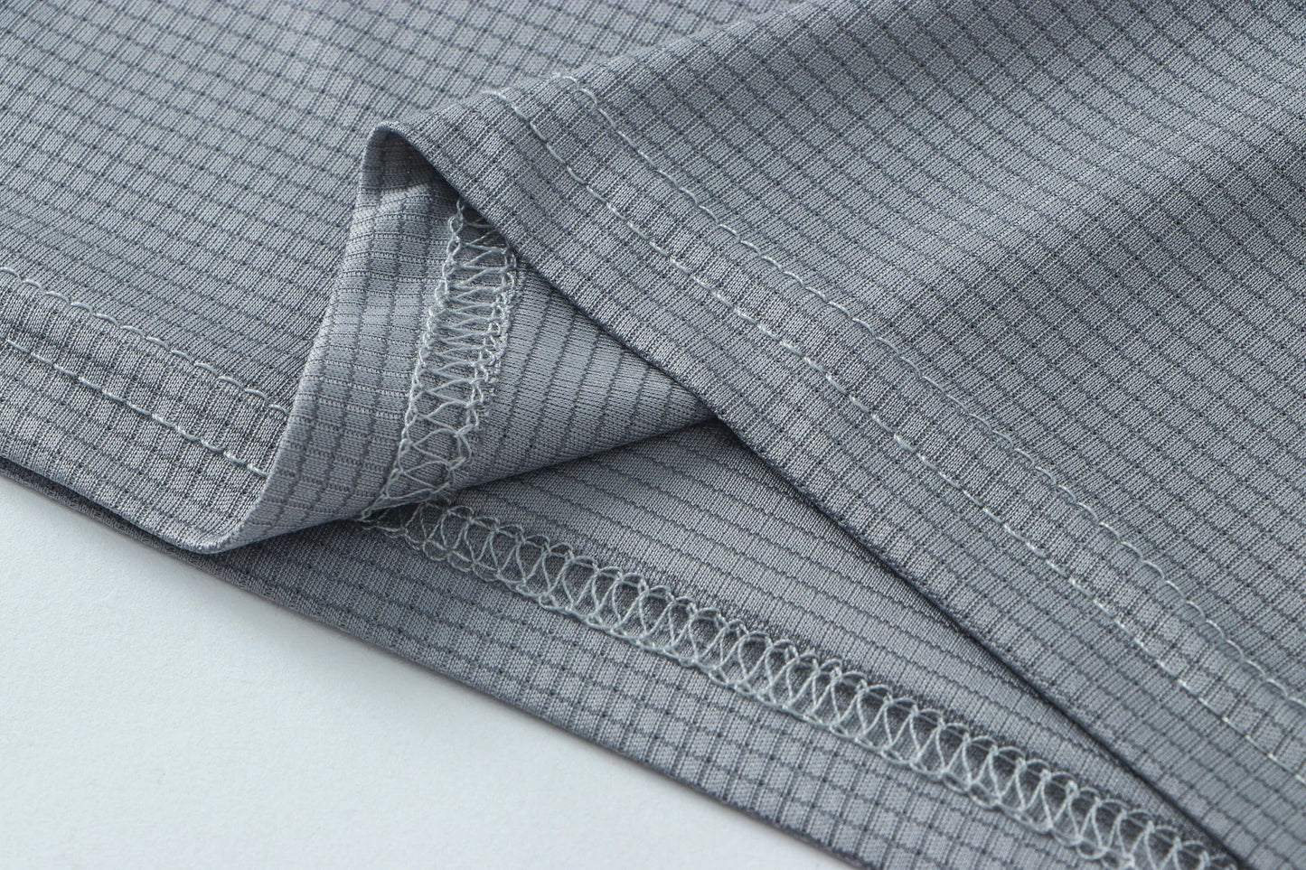 Detail shot of gray fabric with a folded edge and soft texture.