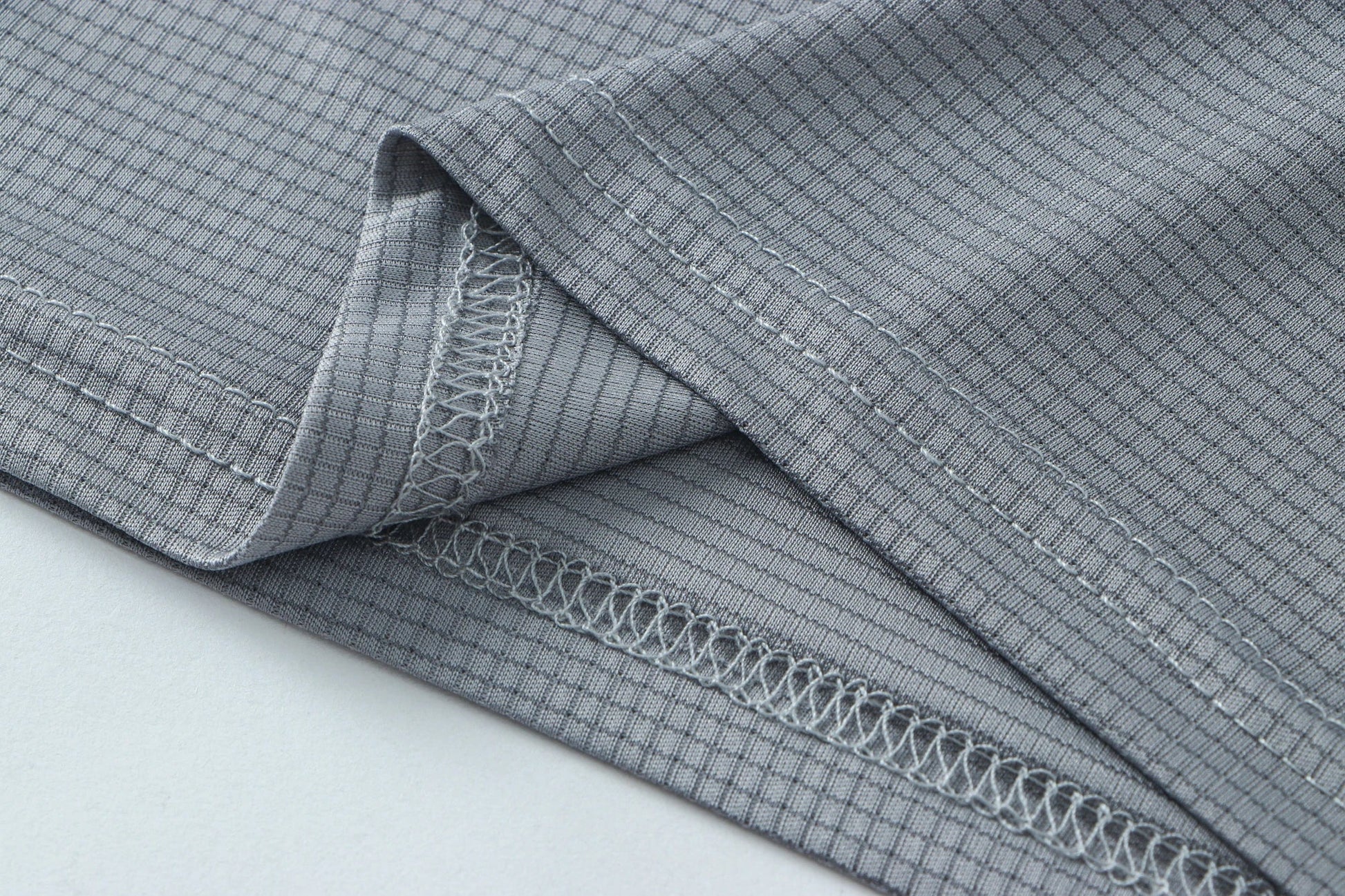 Detail shot of gray fabric with a folded edge and soft texture.
