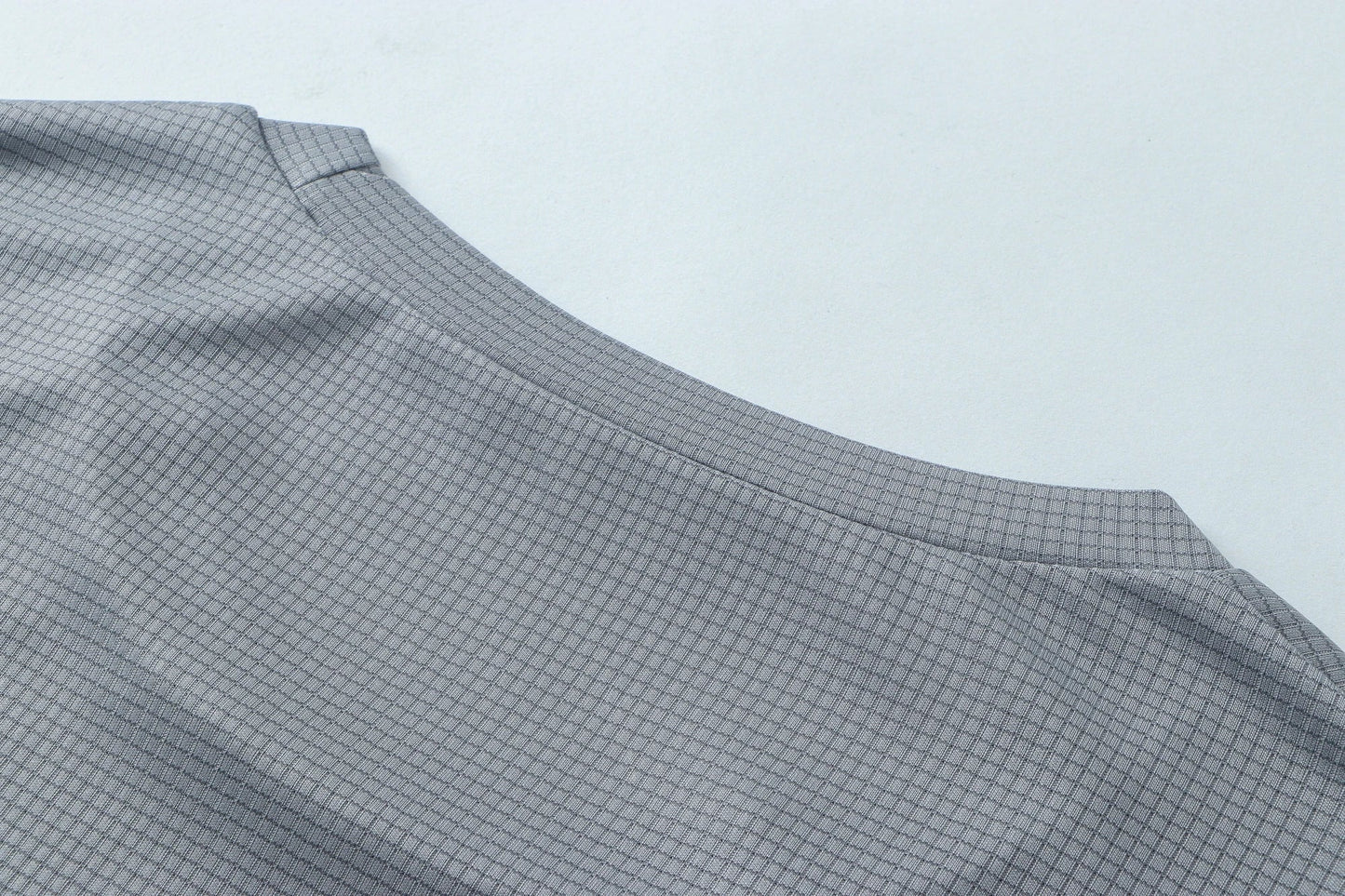 Detail shot of gray fabric with smooth finish and curved edge.